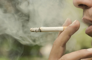 Close up of a man smoking a cigarette.