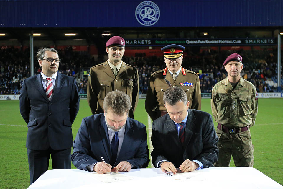 Defence Minister Mark Lancaster signing the Armed Forces covenant with QPR’s CEO Lee Hoos. Photograph by Back Page Images.