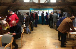 Image of people at a public event looking at promotional material and boards