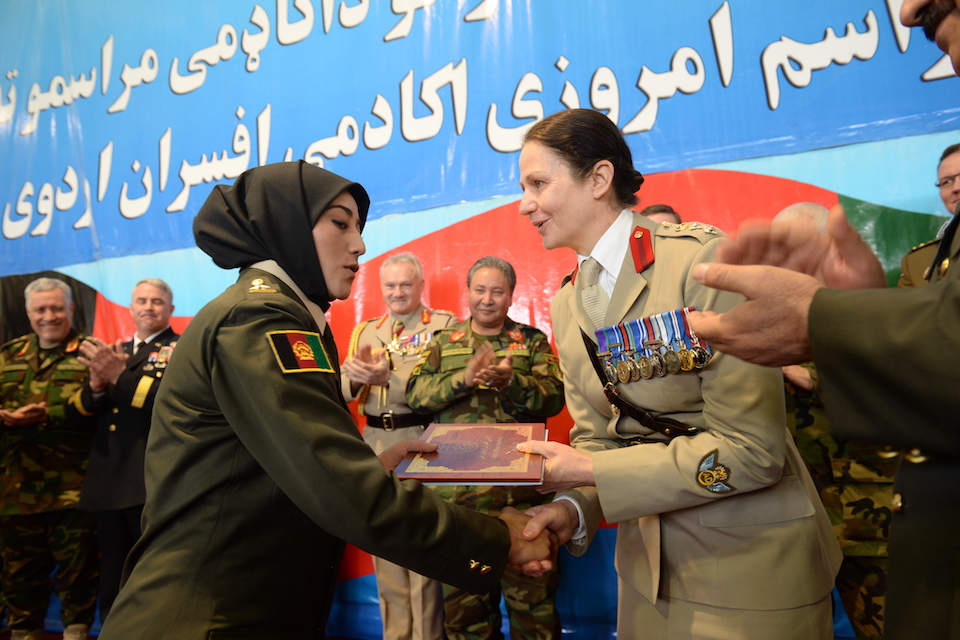 A British officer presents an Afghan cadet with their graduation award