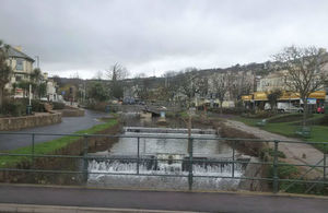 Stream flowing along bottom of channel, with shops on both sides