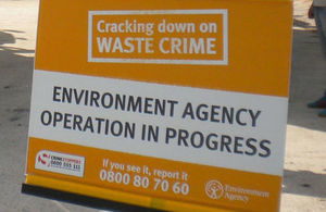 Stock photo of an orange Environment Agency banner which says cracking down on waste crime