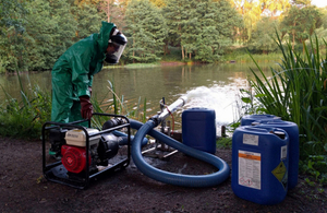 Environment Agency officer dosing Ampthill Reservoir with hydrogen peroxide