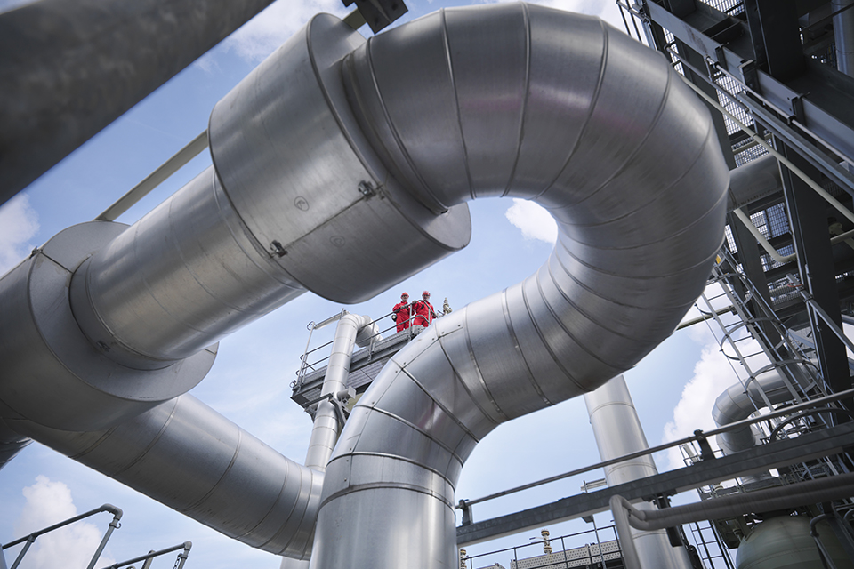 UK Gas picture of huge pipes, with 2 men loking down from above platform, photo credit: Monty Rakusen/Cultura/Getty images