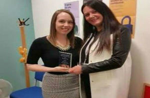 Image of an award being handed to a member of staff