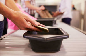 Close up of a man placing his belongings into a tray for an airport security check