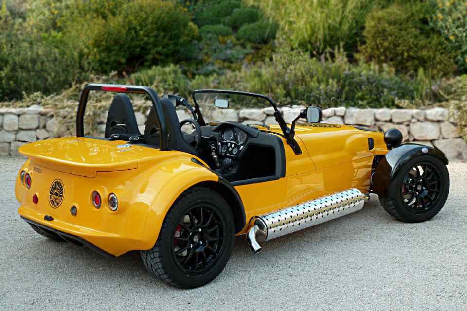 Three-quarter view from the rear of a yellow turbocharged Westfield two-seater sports car.