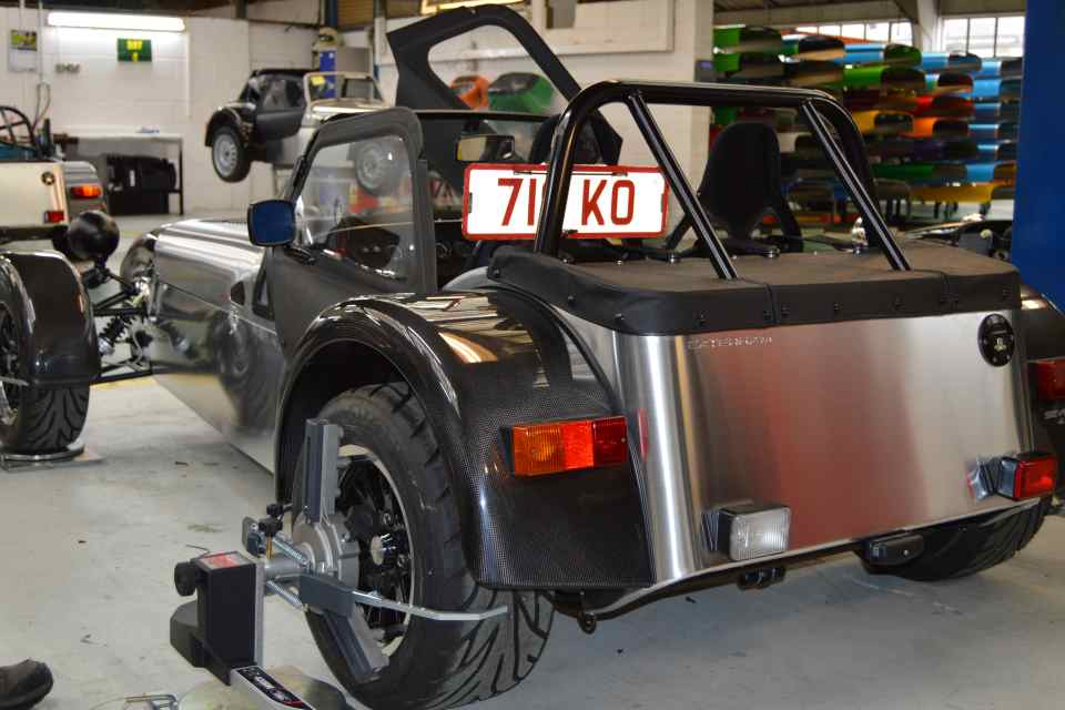 A Caterham test car with monitoring equipment in a company workshop.