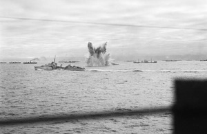 An underwater detonation erupts next to HMS Ashanti during a convoy to Russia in September 1942. The destroyer HMS Eskimo is seen in the foreground. Merchant ships are in the background [Picture: British Newsreel Pictures © IWM (A 12022)]