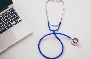 A stethoscope and a laptop on a desk.