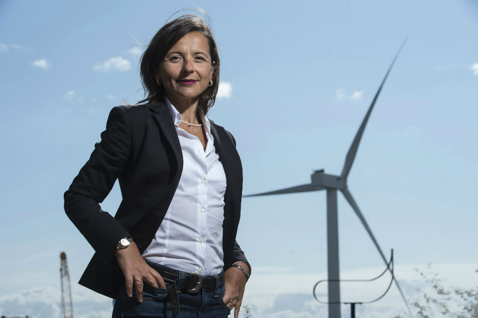 Sabrina Malpede, CEO of ACT Blade, stands in front of a wind turbine