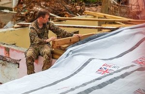 A Royal Marine Commando engineer helps to fix a tarpaulin shelter kit supplied by UK aid to a house on the British Virgin Island of Tortola that was badly damaged by Hurricane Irma. Picture: MOD
