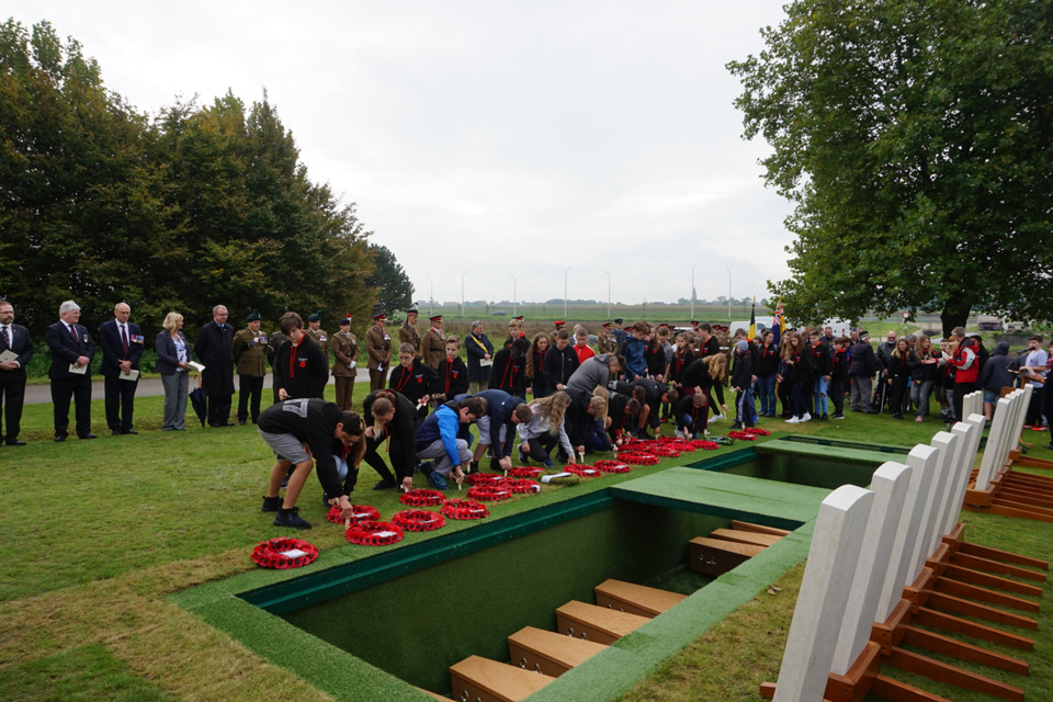 Local children from the Peace Village lay wreaths for the 19 unknown soldiers - Crown Copyright, All Rights Reserved