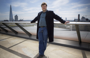 Demand Logic co-founder Joe Short standing on a modern office building terrace with the Shard in the left background.