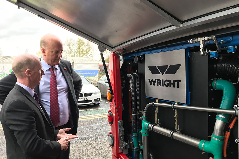 Picture of Chris Grayling looking at a low emission bus engine.