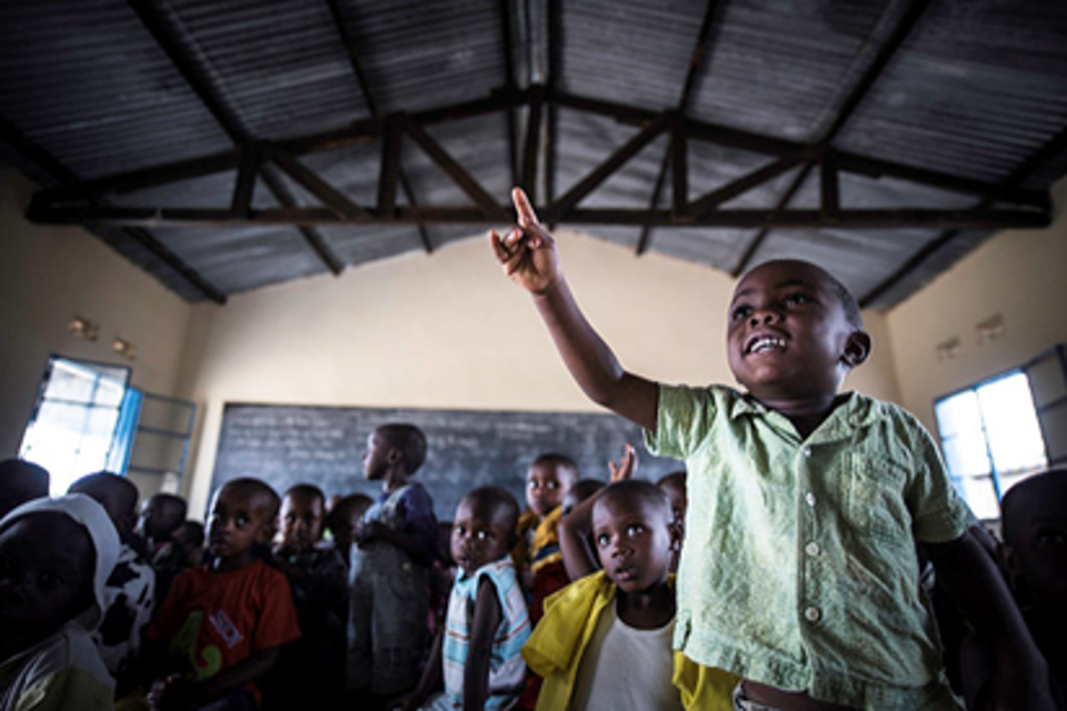 A boy raises his hand in class, Burundi. UNICEF Burundi/Colfs