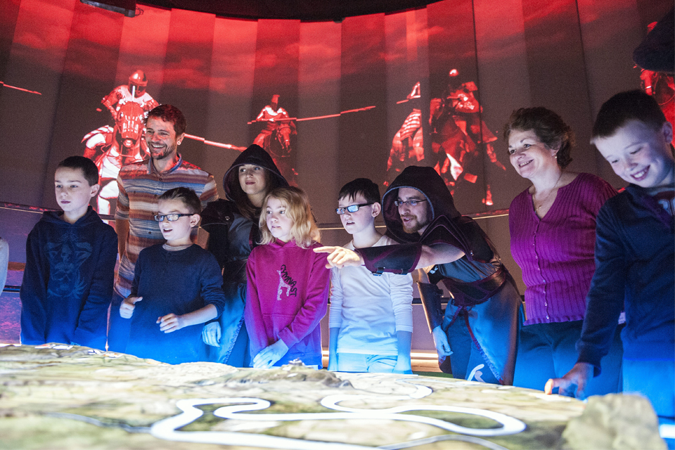 Battle Master leads a group of school pupils through a simulated battle in the Battle Room, Battle of Bannockburn Centre