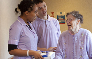 Carers talking to an elderly woman in care home