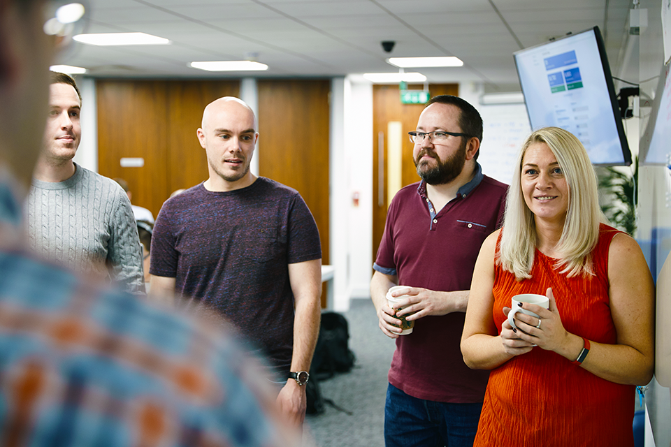 Team of staff stood discussing ideas