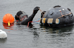 Able Seaman Diver Philip Rowland attaches explosives to a floating mine during a demonstration at the new facility [Picture: Richard Watt, Crown copyright]