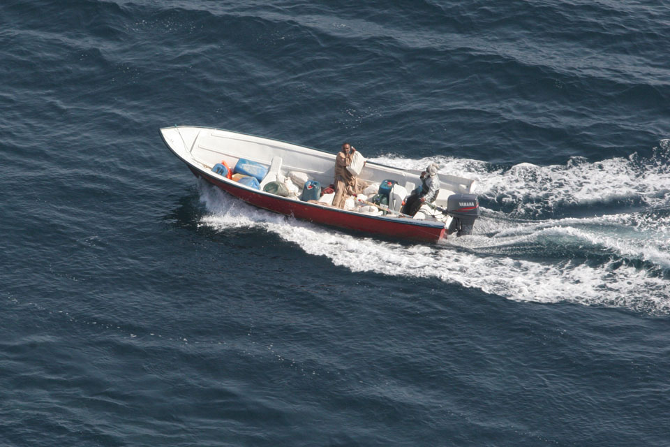 A smuggler prepares to throw a bale of cannabis resin overboard