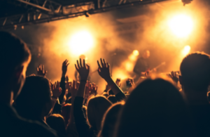 a crowd of people dancing, looking at a stage