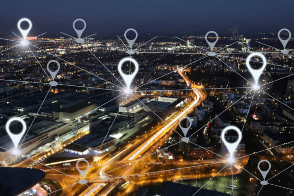 View of a city at night overlayed with location markers (Credit: alexsl / iStock)