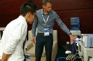 Demonstrating the integrated circuit developed by HiLight Semiconductor at a trade show in Shenzhen, China.