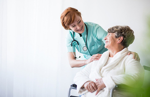 A woman in a wheelchair talking to a nurse