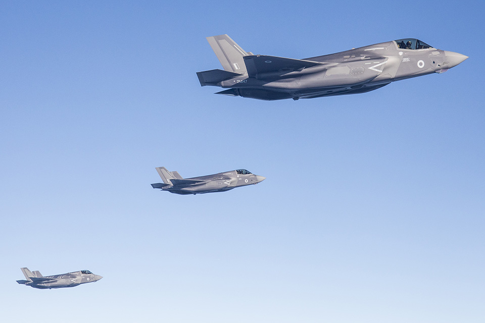 3 F-35 jets flying against a blue sky. 