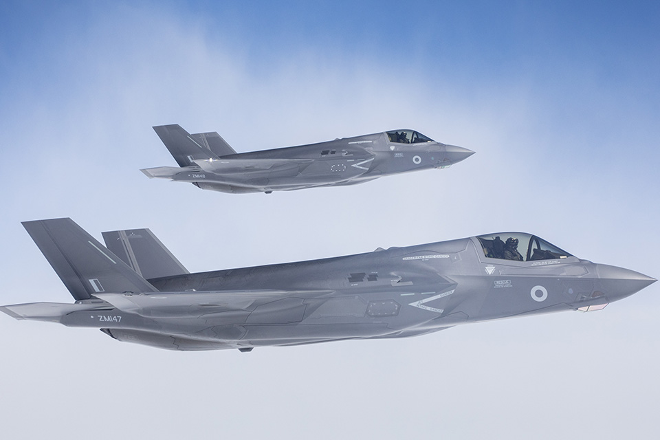 Two F-35 jets flying against the blue sky. 