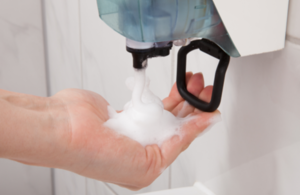 a person using a soap dispenser