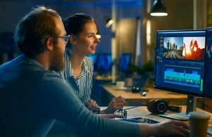 Graduate works with colleague to edit video footage via Gorodenkoff at Shutterstock