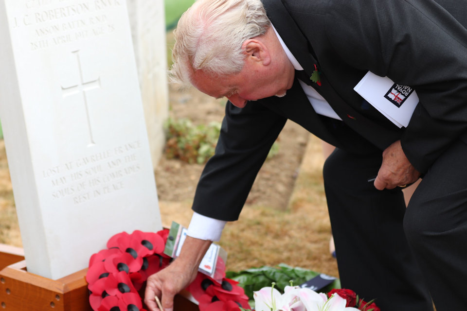 Nephew Frank Treasurer places a poppy at the headstone of his uncle, Crown Copyright, All rights reserved