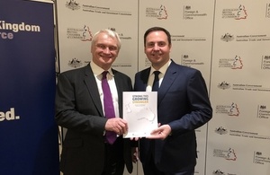 Graham Stuart and Steven Ciobo holding a copy of the UK-Australia investment report.