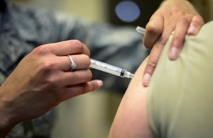 Someone receiving a flu vaccine in arm.
