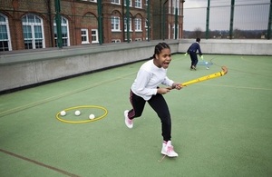 Girl playing hockey in a school playground