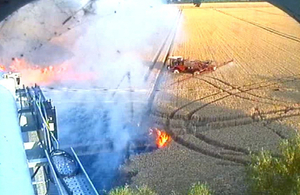 image of fire near the roadside and fields