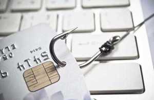 Credit card with fishing hook to illustrate phishing scam