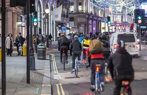 Picture of cyclists on roads, cars and pedestrians.