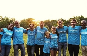 Smiling volunteers stand arm in arm