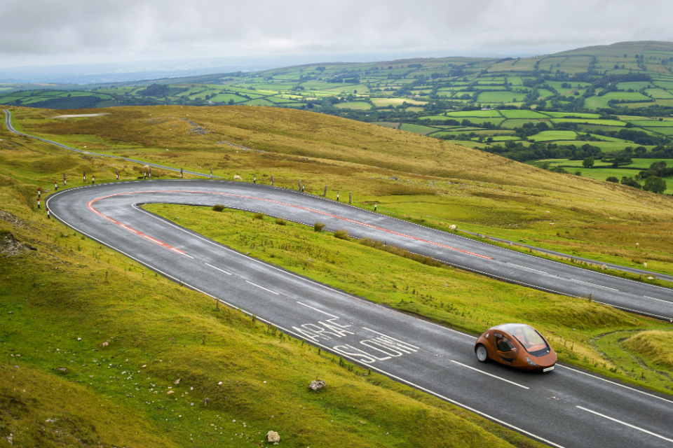 Electric vehicle driving through Welsh countryside