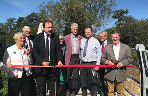 Picture of Jesse Norman cutting a red tape with delegates at Aylesbury Station and Waddesdon Manor.