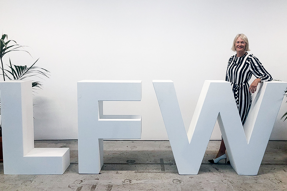 Image of the Minister for Digital and the Creative Industries in front of the London Fashion Week sign.