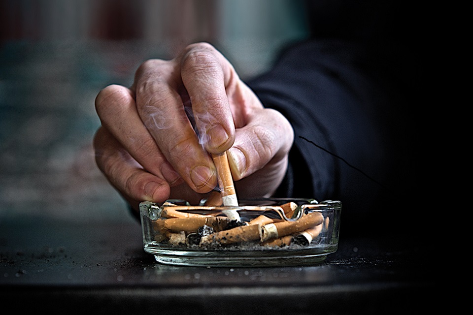 Hand stubbing out cigarette