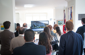 The crowd looks on at the promotional video.