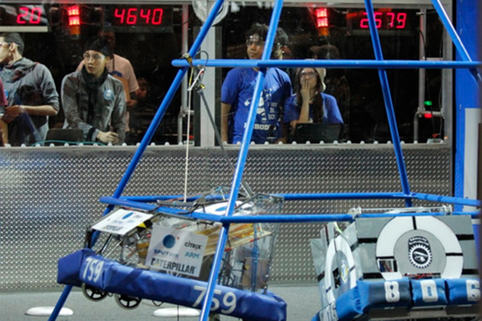 The team's robot climbs a tower.