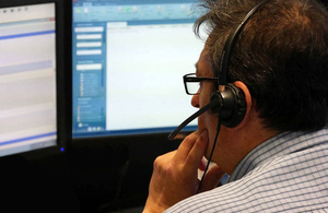 Man with headset looking at computer