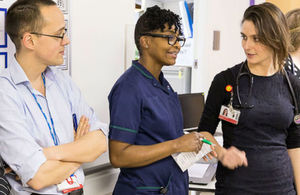 Three doctors chatting in hospital corridor