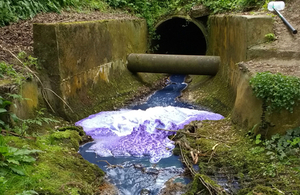 Purple waste can be seen flowing out of a surface water outfall and into the River Yeo